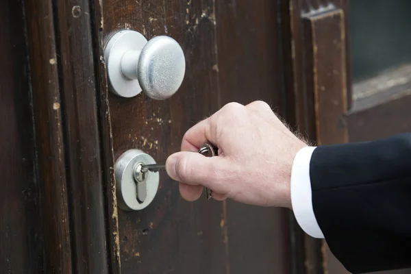 Close-up van de hand met sleutel op een deur — Stockfoto