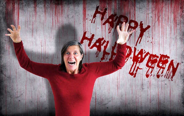 Happy Halloween besprutas på väggen bredvid skrikande kvinna — Stockfoto