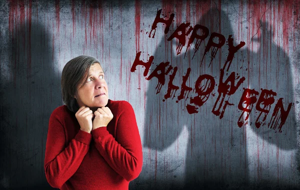 Felice Halloween spruzzato sul muro accanto alla donna spaventata — Foto Stock