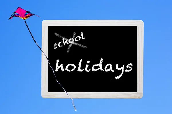 Pizarra con palabras "vacaciones escolares" y una cometa —  Fotos de Stock