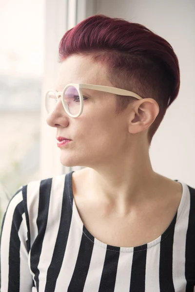 Red-haired woman looking through window — Stock Photo, Image