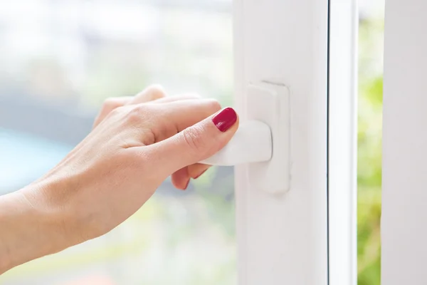 Close-up van vrouw hand een venster openen — Stockfoto