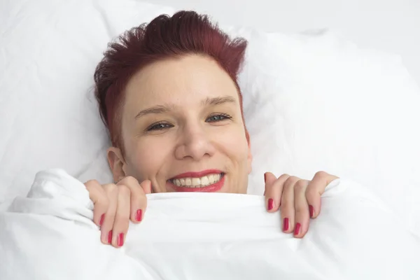 Mulher ruiva na cama com um grande sorriso — Fotografia de Stock