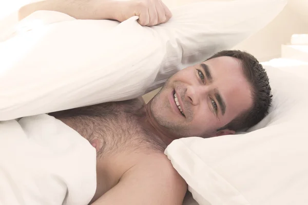 Hombre sin camisa en la cama y sonriendo — Foto de Stock