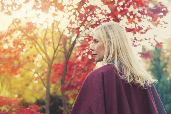 Blond kvinna i en park i höst — Stockfoto