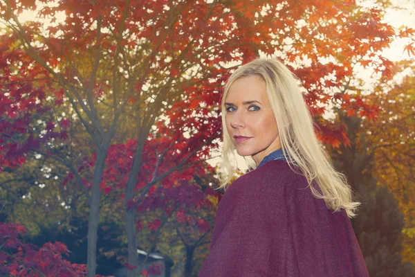 Blond woman in a park in autumn — Stock Photo, Image