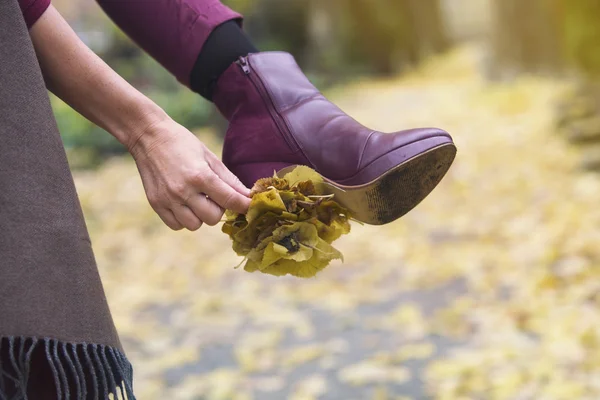 Gros plan de la chaussure de la femme avec des feuilles collées sur sa guérison — Photo