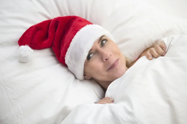 Mujer en la cama con sombrero de Santa — Foto de Stock