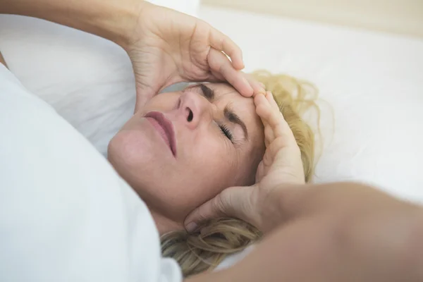 Mujer en la cama con dolor — Foto de Stock