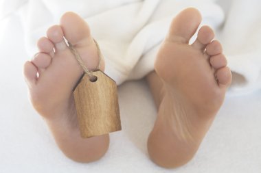 ahşap etiketi ile yatakta çıplak ayakları
