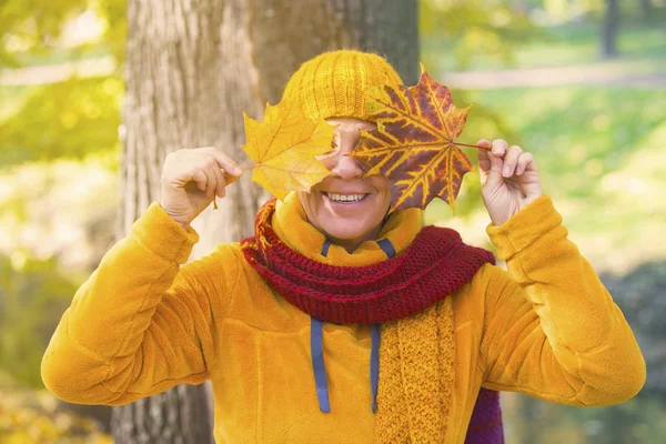 Femme dans le parc tenant des feuilles devant son visage — Photo
