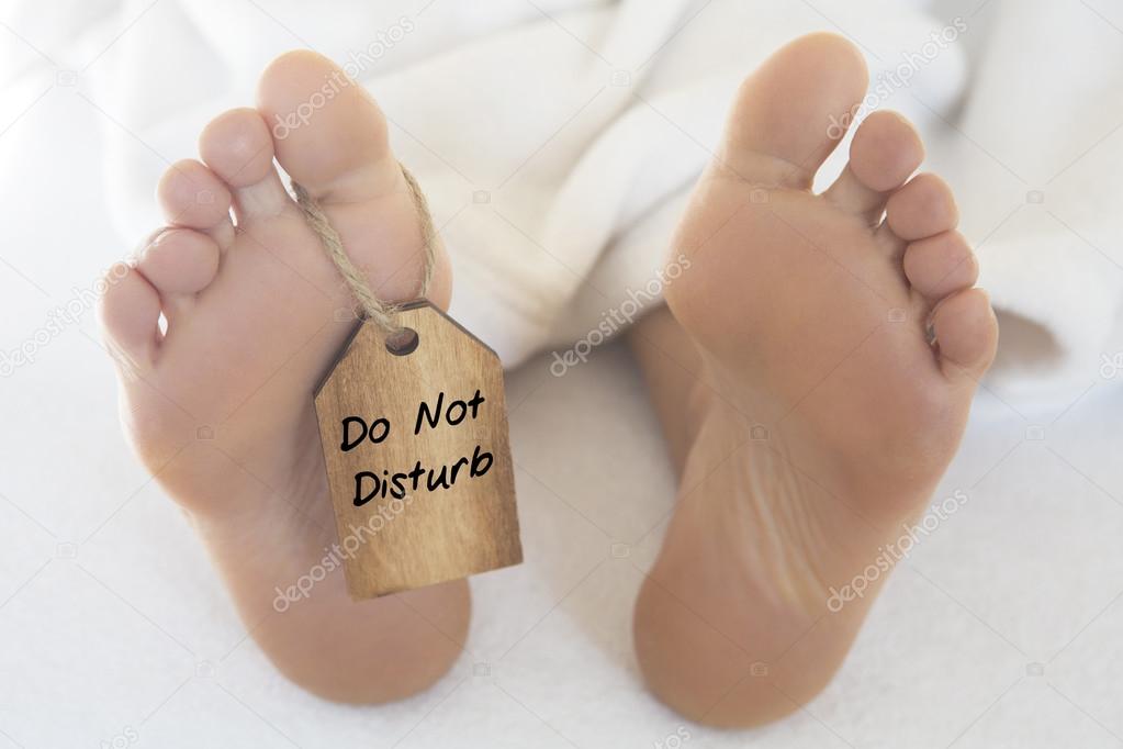 naked feet  with wooden tag 'do not disturb