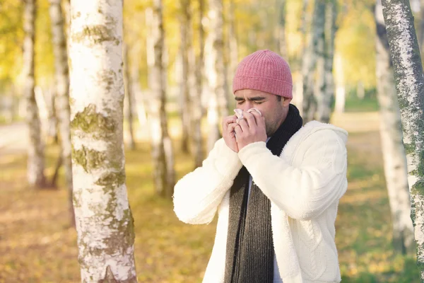 Mann im Park pustet sich die Nase aus — Stockfoto