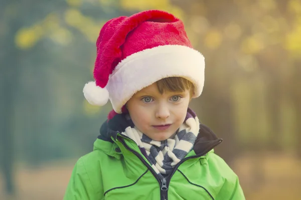 Garçon avec chapeau de Père Noël dans le parc — Photo