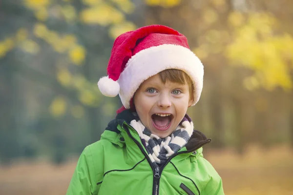 Garçon avec chapeau de Père Noël dans le parc — Photo