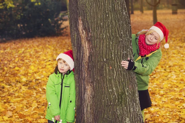 Mère et fils dans le parc avec chapeaux de Père Noël — Photo