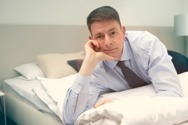 Portret biznesmen leżąc na łóżku — Zdjęcie stockowe