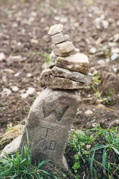 Hraniční kámen na hnědé pole — Stock fotografie