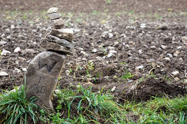 Grenzstein an einem braunen Feld — Stockfoto