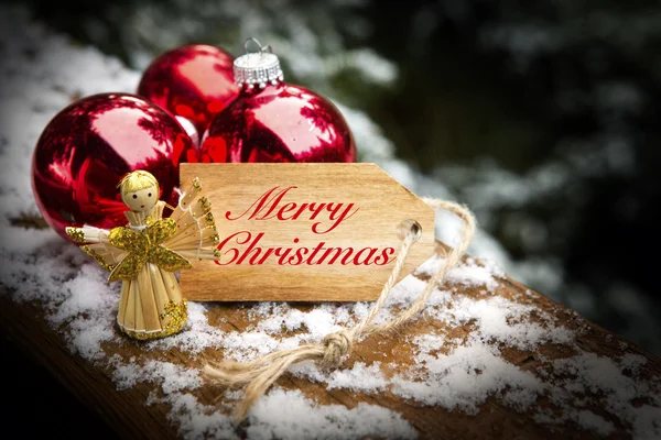 'Feliz Natal' em etiqueta de madeira com anjo — Fotografia de Stock