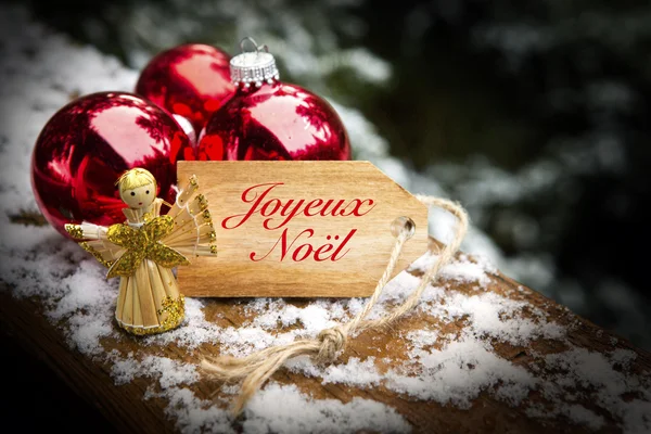 Francês 'Joyeux Noel' (Feliz Natal) com bolas de Natal e — Fotografia de Stock