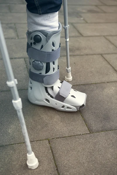 closeup of person walking with cast on foot