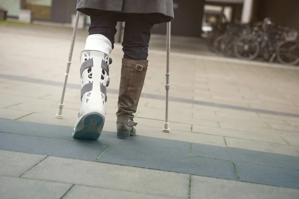 Primer plano de la mujer caminando con muletas — Foto de Stock