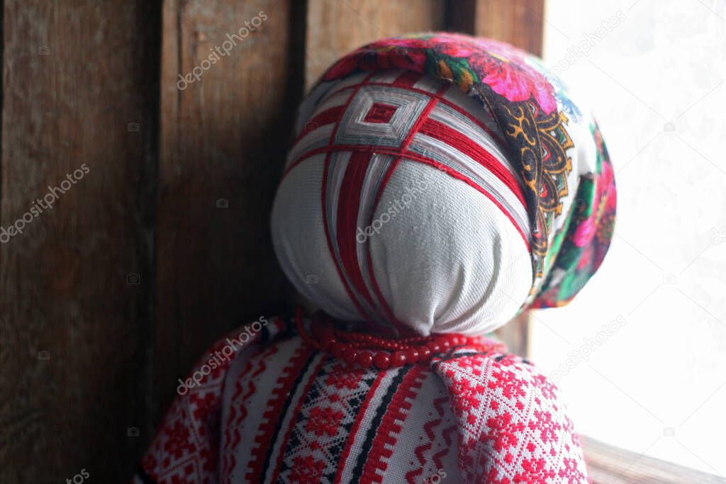  Ukrainian motanka doll on a background of windows and wood