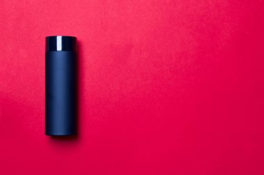 Kırmızı arkaplandaki siyah termos bardağı kopyalama alanı ile.