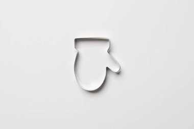 Beyaz renkli kağıt arka planda eldiven şeklinde kurabiye keskisi. İzole. Kapat. maket yap.