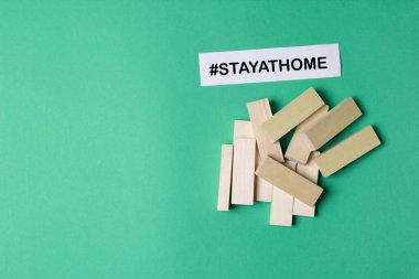 jenga ahşap bloklar telif alanı ve hashtag yeşil renkli kağıt arka planda evde kalır.