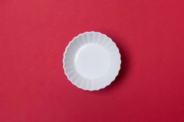 Κενό Άσπρο Πιάτο Στο Κόκκινο Χρωματιστό Υπόβαθρο Εγγράφου — Φωτογραφία Αρχείου