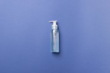 Mavi zemin üzerinde sıvı bulunan kozmetik şişesi.