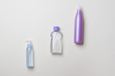 Sarı arka planda köşegen üzerinde üç farklı kozmetik şişe var..