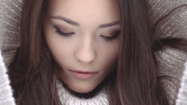 Beautiful natural face of young brunette woman wearing woollen hood. — Stock Video