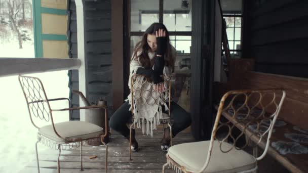 美丽的黑发女人，戴着针织毛衫，坐在窗边. — 图库视频影像