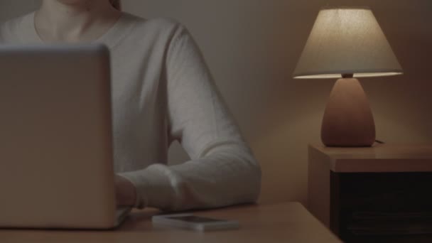 Μια γυναικεία χέρια απασχολημένος πληκτρολογώντας σε ένα φορητό υπολογιστή και το τηλέφωνο picking σε κοντινό πλάνο. — Αρχείο Βίντεο