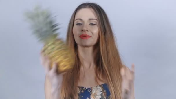 Jonge sexy meisje met rode lippen plezier met ananas. — Stockvideo