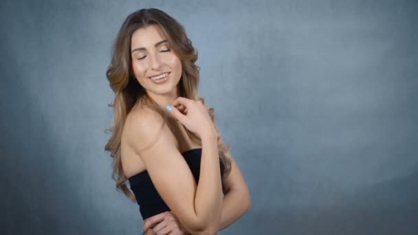 Glückliche junge Frau mit perfektem Lächeln isoliert auf grauem Hintergrund. — Stockvideo