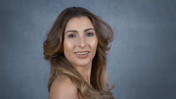 Gelukkig jonge vrouw met perfecte glimlach geïsoleerd op een grijze achtergrond. — Stockvideo