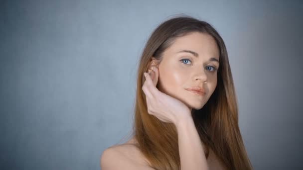 Gelukkig jonge vrouw met perfecte gezicht geïsoleerd op een grijze achtergrond. — Stockvideo