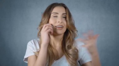 Gri arka plan üzerinde izole telefonda konuşan kadın.