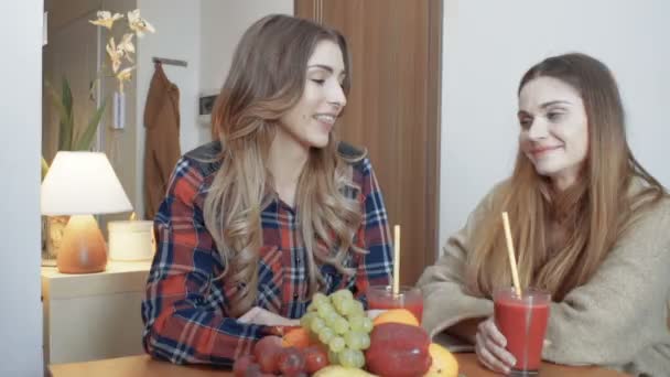 Δύο χαρούμενα κορίτσια πόσιμο smoothie και να κουτσομπολεύουν. — Αρχείο Βίντεο