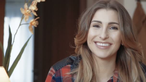 Portrait de belle jeune femme heureuse aux cheveux longs dans la chambre . — Video