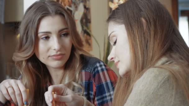 Két vidám lány turmix fogyasztása és fecseg. — Stock videók