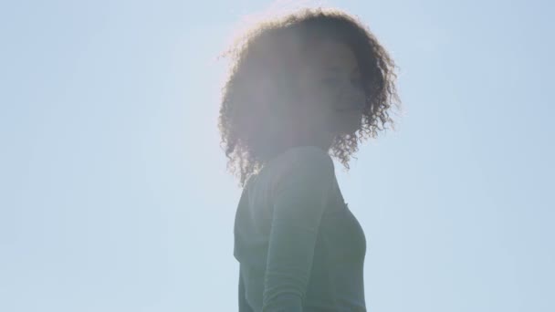 Young afro american woman relaxing in park with a sunset behind her. — Stock Video