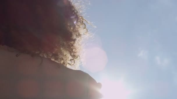 Main féminine touchant le ciel bleu et se levant au soleil . — Video