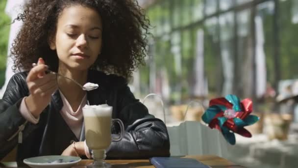 Portrait de jeune femme afro-américaine dégustant une tasse de café au café . — Video