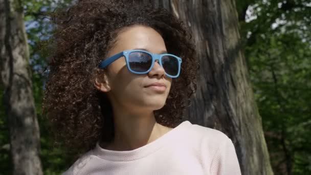 Closeup portrait of a beautiful mixed race woman in sunglasses, outdoor. — Stock Video