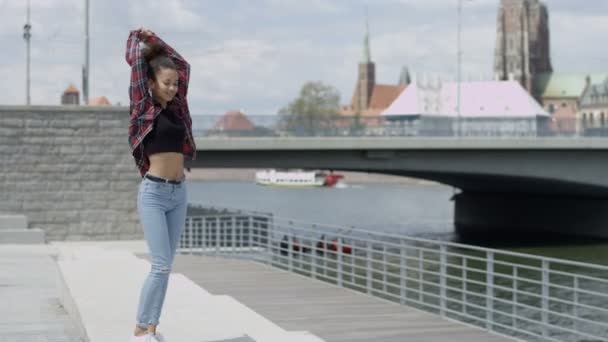 Retrato de una joven afroamericana con camisa a cuadros, al aire libre . — Vídeo de stock